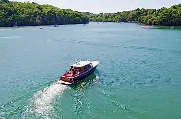 A boat sails down the River Fal.