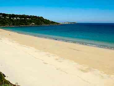 Yellow sand and blue sea on Carne beach in Cornwall.