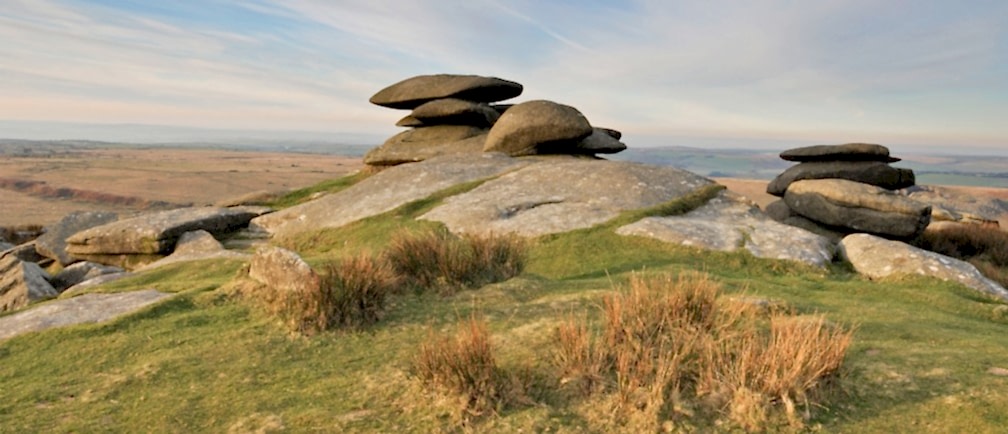 Flat stone cairns atop a hill in the Cornish countryside.