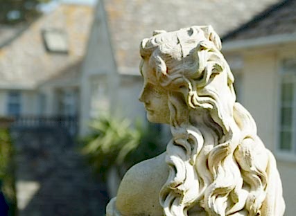 A statue of a lady in The Nare hotel gardens.