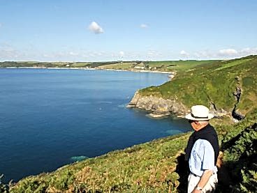 A man looks back at the hotel from the coast path